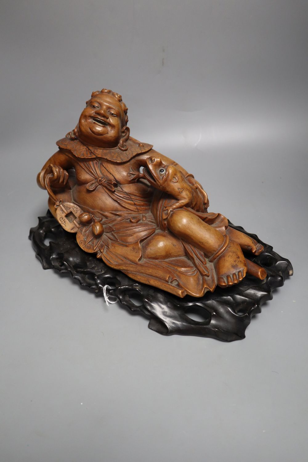 A Chinese hardwood group of Liu Hai and his three legged toad, early 20th century, together with an ebonised wood stand, length 36cm